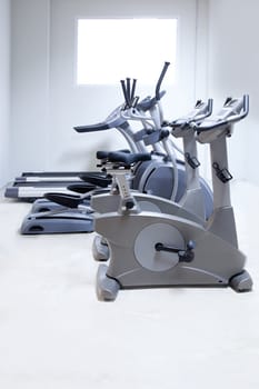 elliptical cross trainer, stationary bicycle and treadmill in gym