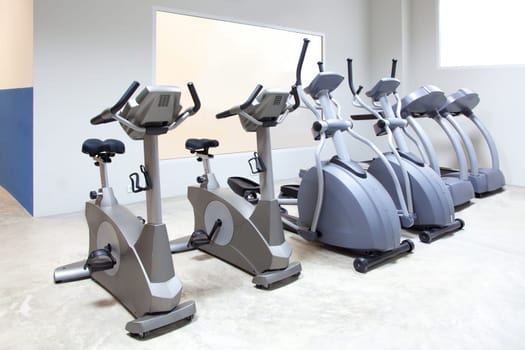 elliptical cross trainer, stationary bicycle and treadmill in gym