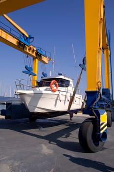 boat yellow crane travelift lifting motorboat for yearly antifouling hull treatment