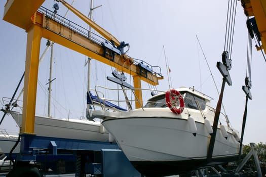 Dock crane elevating a fishing boat in Mediterranean marina