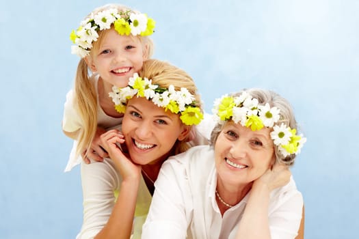Portrait of daughter over her mother and grandmother with flowers on their heads