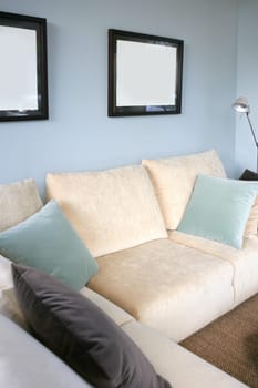 Living room with cream sofa, soft blue wall, interior design