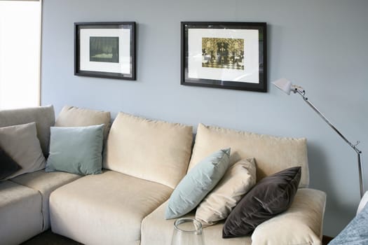 Living room with cream sofa, soft blue wall, interior design