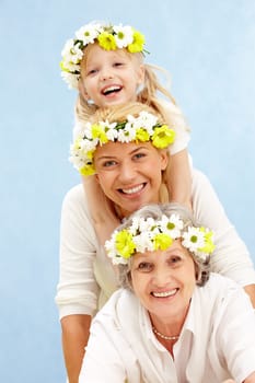 Portrait of daughter, mother, grandmother in line on a blue background