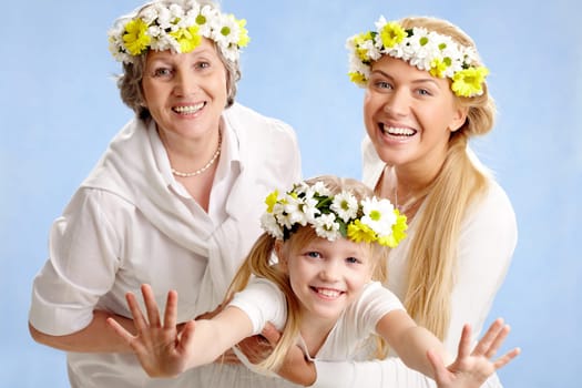 Image of grandmother and mother holding child on their hands
