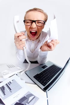 Photo of exhausted secretary shouting with phone receiver and paper in hands while sitting in office