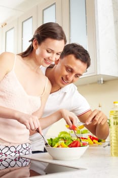 Portrait of happy couple with forks tasting salad