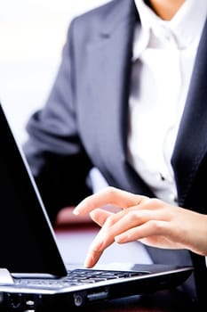 Magnified photo of business woman pushing button of laptop