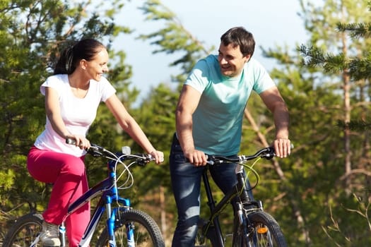 A young happy couple riding bicycles together
