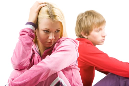 Image of sad girl with troubled guy at background after having an argument