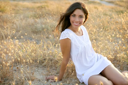 Beautiful indian brunette having a rest on a golden summer field