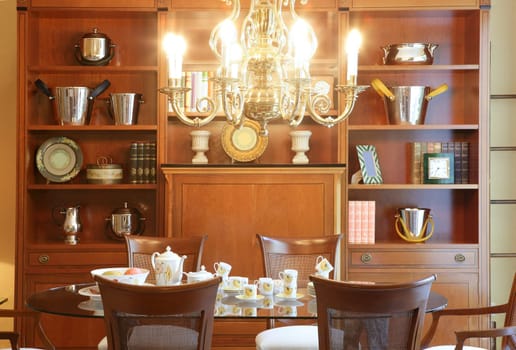 Classic living room table library furniture glowing chandelier warm wood