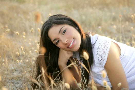 Beautiful indian brunette having a rest on a golden summer field