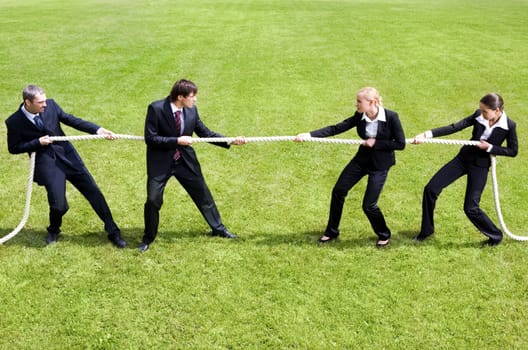 Photo of tug of war between business people