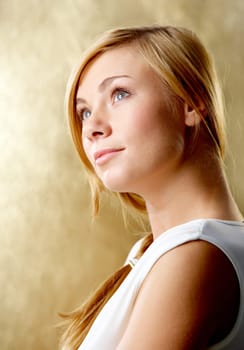 Portrait of pretty girl looking aside with smile over golden background