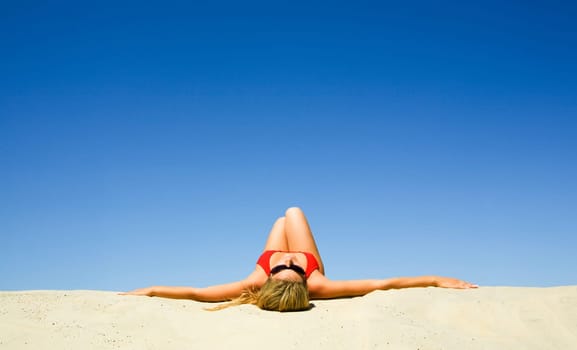 View of beautiful woman lying on the sand getting pleasure