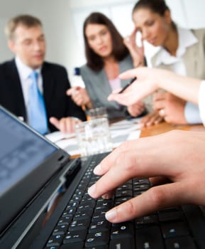 Image of human hands typing on the laptop during a seminar