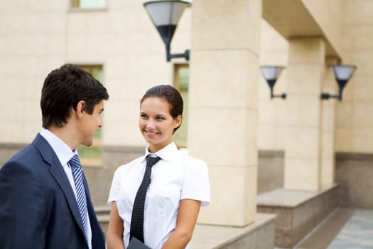 Photo of confident businesswoman looking at associate while communicating with him