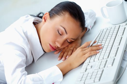 Image of young businesswoman sleeping on workplace with her head on keyboard
