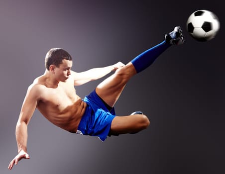 Professional sportsman kicks soccer ball