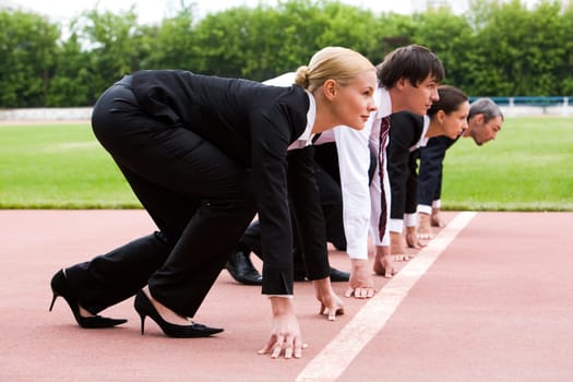 Row of business people getting ready for race