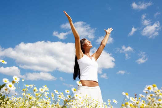 Image of happy female standing with raised arms on summer day