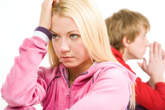 Image of sad girl with troubled guy at background after having an argument