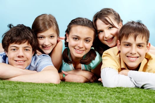 Portrait of five lying friends looking at camera and smiling