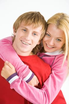 Portrait of happy guy being hugged by his pretty girlfriend