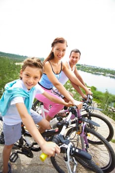 Portrait of happy family riding bikes in summer