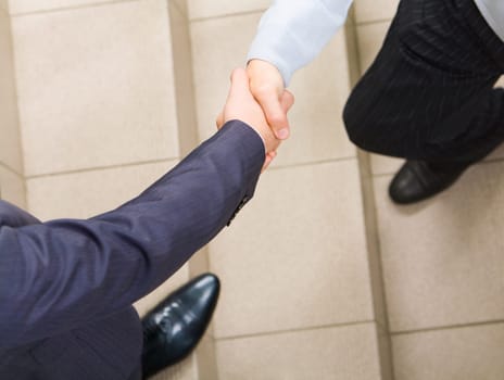 Photo of handshake of businessmen on staircase