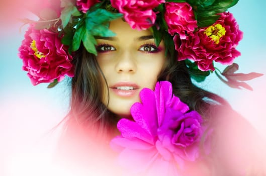 Beautiful woman with bright flowers looking at camera
