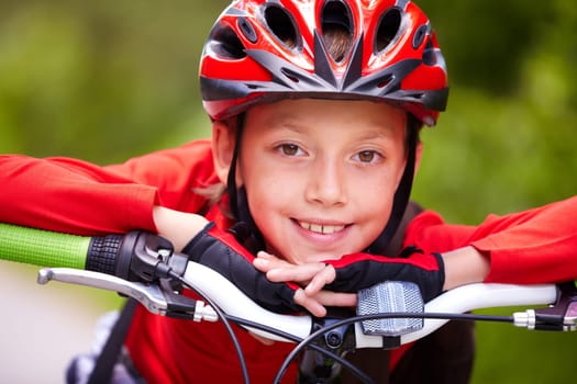 Close-up of a little boys face on bike looking at camera and smiling