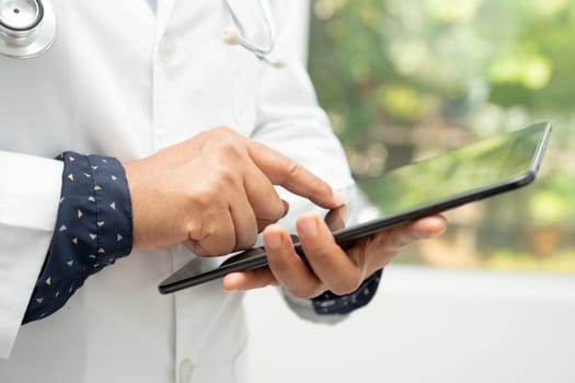 Asian doctor use digital tablet for search data to treat patient in hospital.
