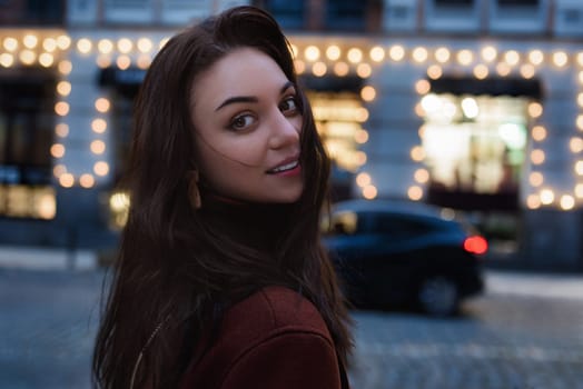 Portrait of a beautiful brunette walking through the city at night.