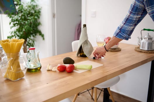 Healthy organic raw vegetables for salad on the table near an oil can with fresh extra virgin oil on the kitchen table. Still life with healthy food ingredients