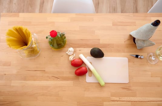 View from above of healthy organic raw vegetables for salad on the table near an oil can with fresh extra virgin oil on the kitchen table. Still life with healthy food ingredients