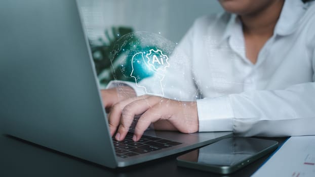 Businesswoman using computer and showing brain icon of AI represents the concept of learning of artificial intelligence systems and using artificial intelligence as a work assistant.