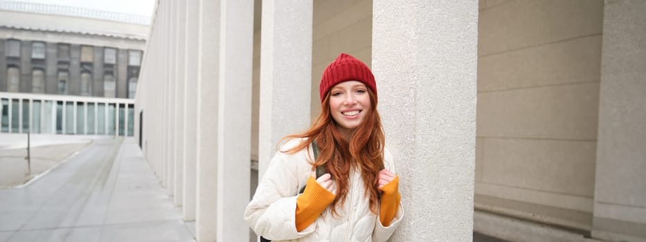 Happy redhead girl, tourist going around town, exploring sighsteeing places in city, backpacking around europe, enjoys travelling.