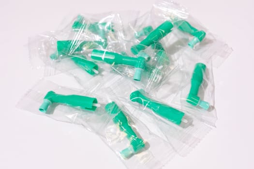Top View Green Disposable Prophy Angles with Brush, Ergonomic Shape on White Background. Dentistry, Orthodontic Product. Oral Hygiene. Horizontal Plane . High quality photo