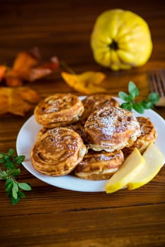 Cooked fried round pancakes with quince filling, cute pancakes with a smile, autumn recipes, on a wooden table