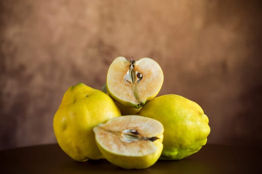 Ripe natural autumn quince on a dark wooden table.