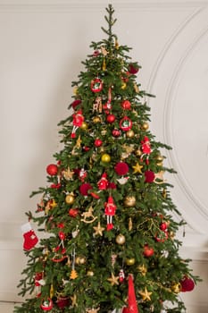 Big christmas tree decorated with beautiful red baubles at home. Copy space.