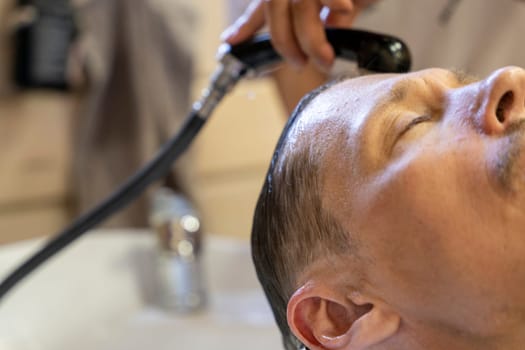 a man washes his hair while visiting a hairdresser. a hairdresser washes a client's hair before a haircut in a beauty salon. Men's haircut in a barbershop.