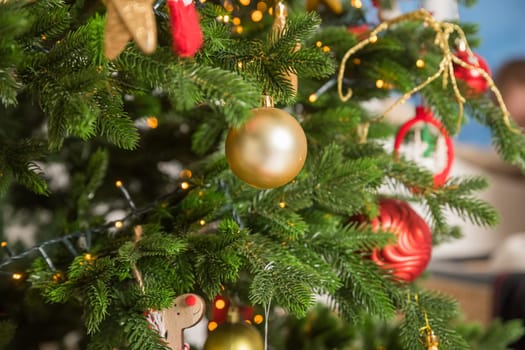 Big christmas tree decorated with beautiful red baubles at home. Copy space.