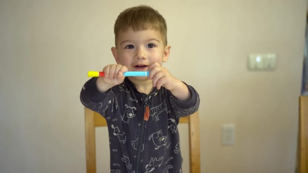 A little boy closes the cap of a felt-tip pen. Child with a felt-tip pen. 4k