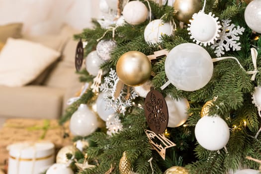 Photo of luxury gift boxes under Christmas tree, New Year home decorations, golden wrapping of Santa presents