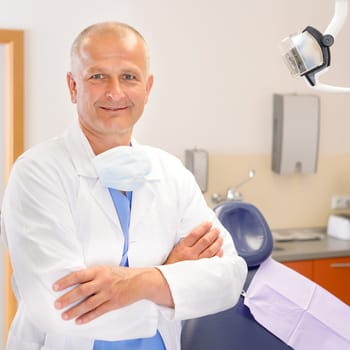 Portrait of mature dentist surgeon posing at office