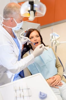 Dentist checkup procedure female patient sitting on chair in dental office