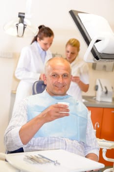 Mature man being treated at dental surgery smiling